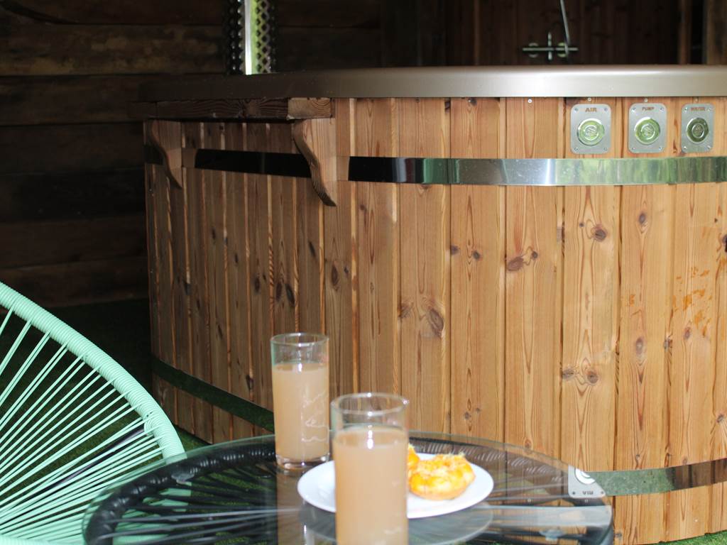 Le bain nordique, en bois, dont l'eau est chauffée à 38° grâce à un poêle à bois;. Un vrai moment de détente romantique à souhait grâce aux bulles et aux leds ainsi que  à la vue de la nature qui s'offre devant vous