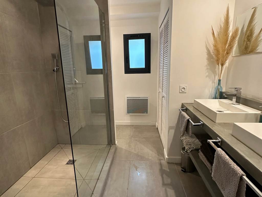 Salle de bain moderne avec grande douche à l’italienne et finitions soignées