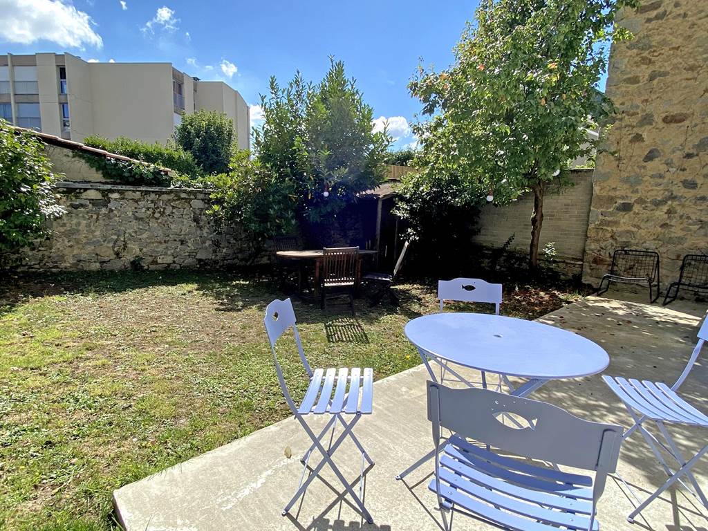 Jardin paisible avec terrasse, offrant intimité et confort pour vos repas ou moments de détente à Limoges.