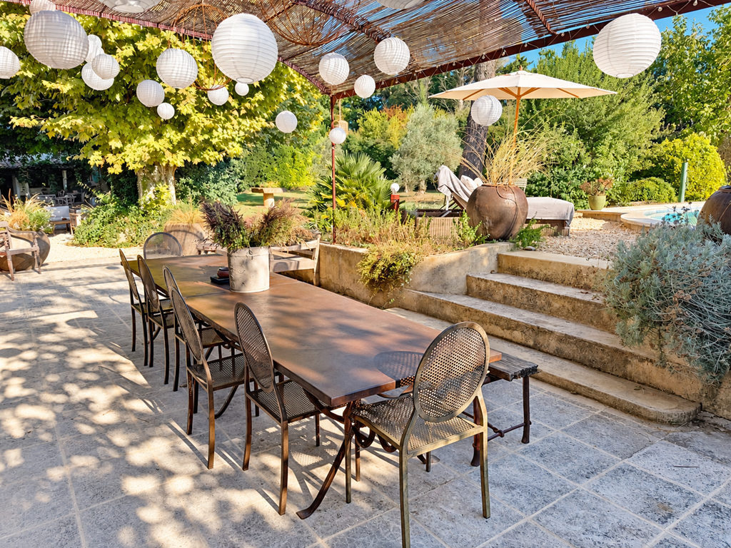 "La grande table de l'orangerie, à l'ombre de la pergola, entre jardin et piscine"