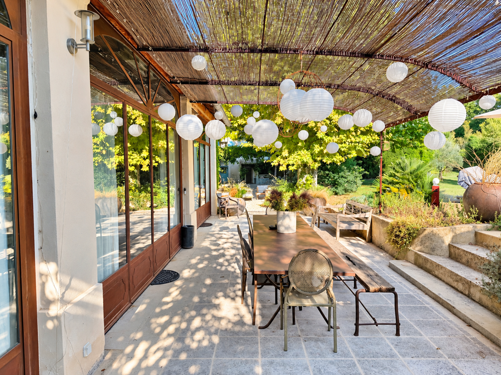 "la terrasse de la suite de l'Orangerie, à l'ombre des lanternes et ouverte sur le jardin"