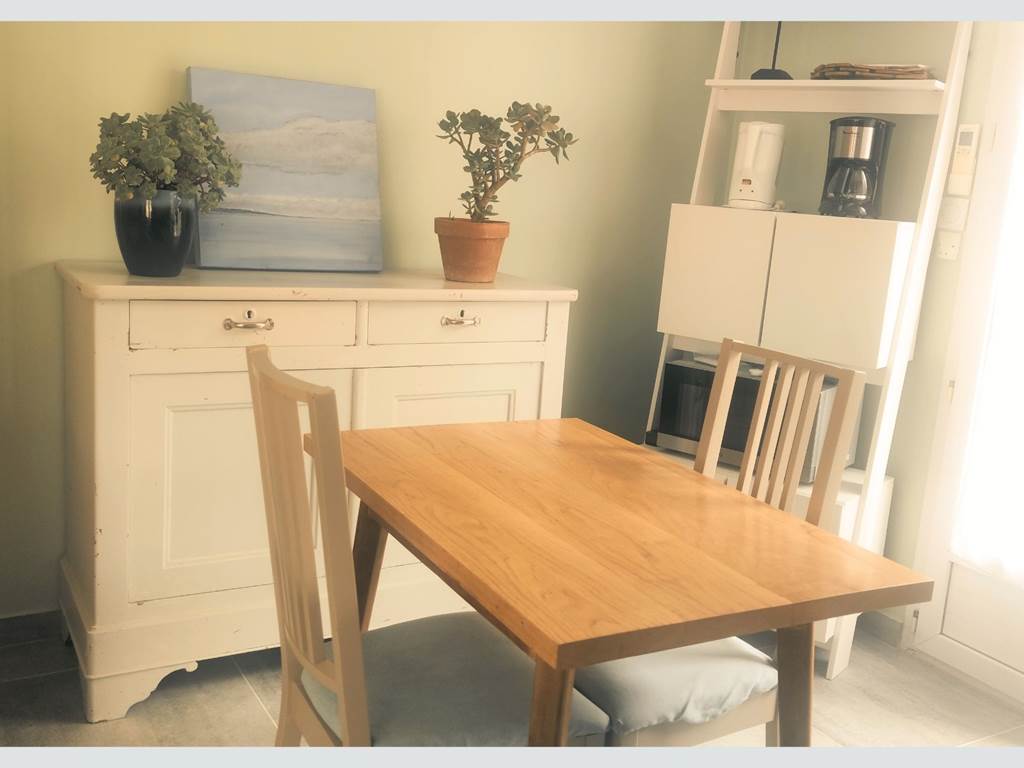 Ambiance douce pour des repas en toute simplicité Ce coin repas intérieur marie confort, clarté et décoration locale, parfait pour savourer chaque instant