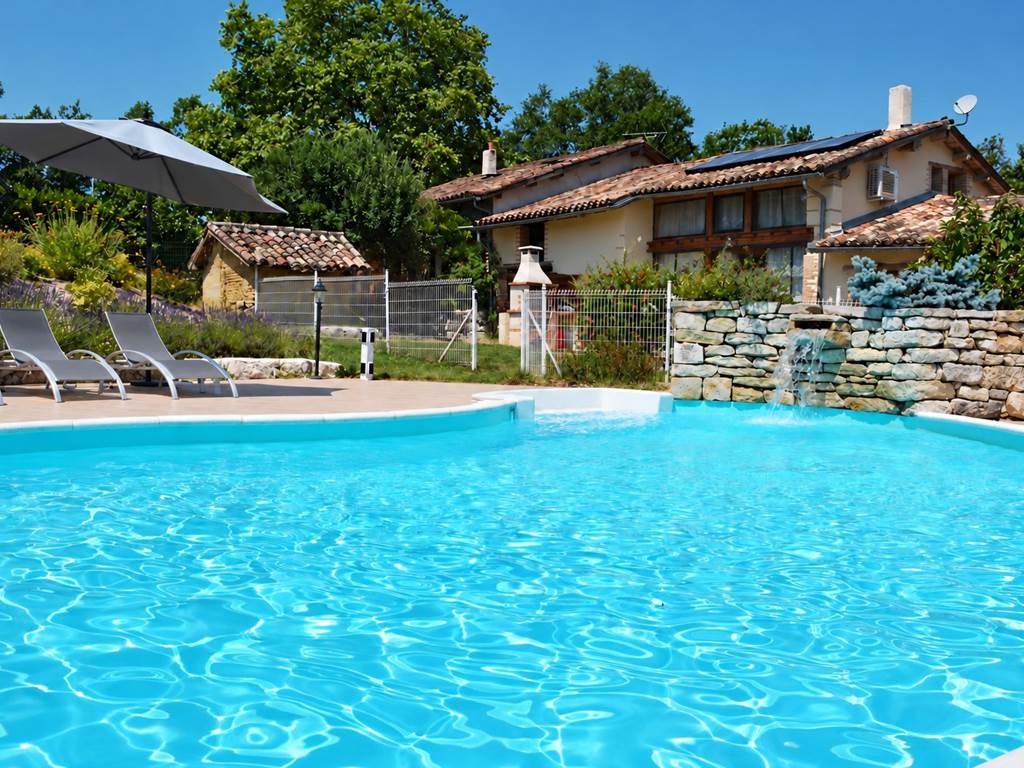 Piscine, cascade et transats gris