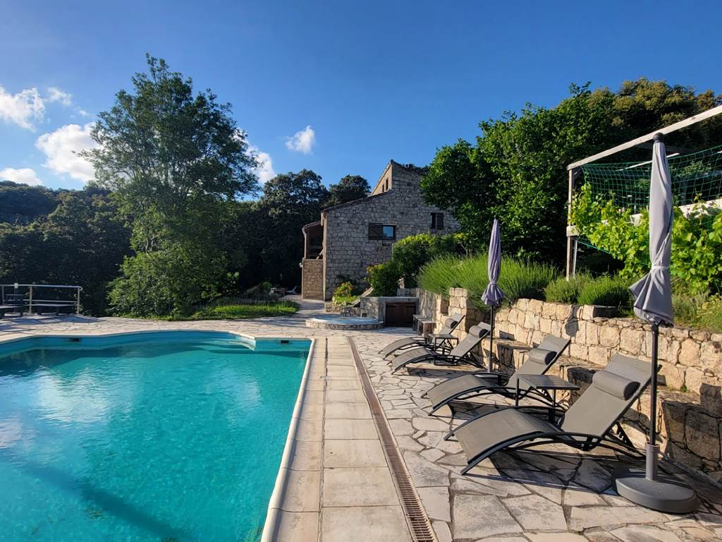 Espace détente avec transats modernes au bord de la piscine avec vue sur les montagnes.