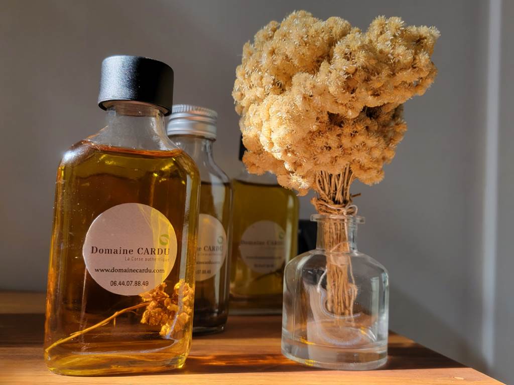 Produits artisanaux locaux : huile d'immortelle et fleurs séchées pour une immersion sensorielle.