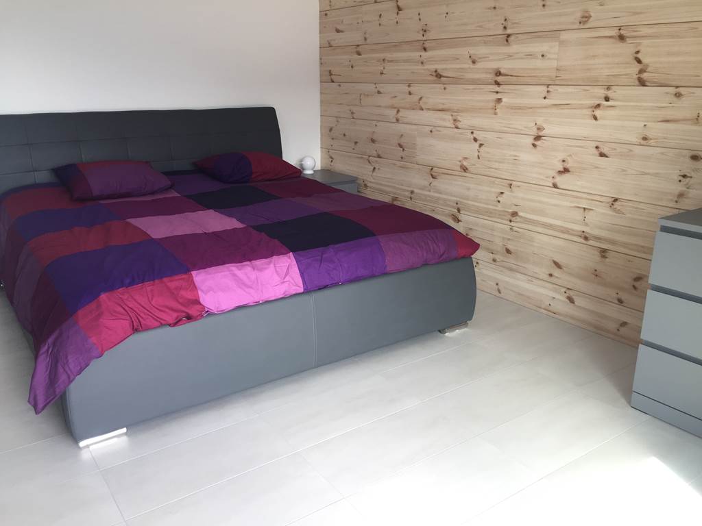 Chambre avec lit King size et mur en bois finlandais