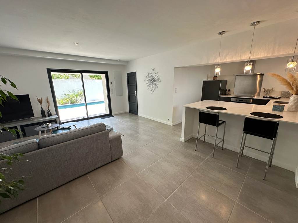 Salon contemporain baigné de lumière, idéal pour se détendre après une journée au soleil