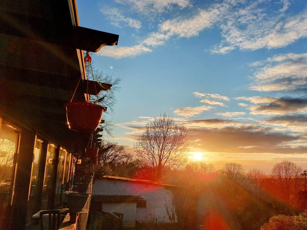 Le soleil couchant joue à -ric hochet- sur les baies vitrées de la salle à manger panoramique de notre Maison d'hôtes Le Ranch des Lacs