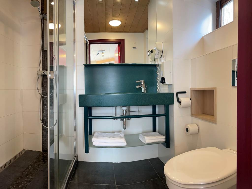 Salle de bain privative des Chambres 11 - 21 comprenant une belle douche Italienne, un lavabo, un sèche cheveux et toilettes