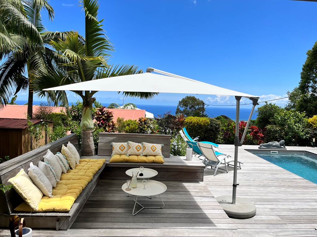 Espace repos sur piscine chauffée et jardin tropical avec vue mer