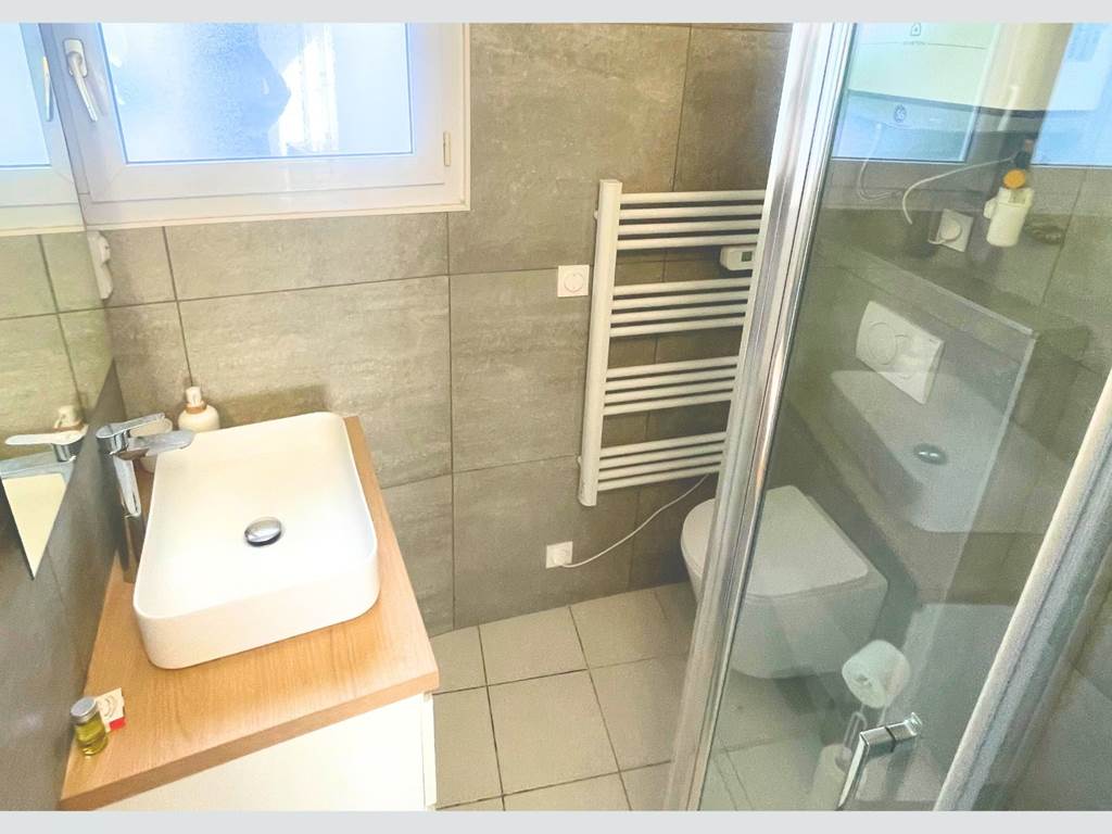 Maison Réthaise 2 – Salle d’eau lumineuse Espace soigné avec équipements modernes et rangements, pensé pour votre bien-être au cœur du centre-village.
