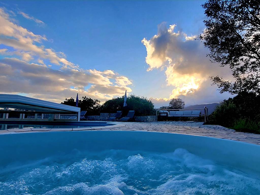 Moment de calme au bord de la piscine du domaine sous un ciel spectaculaire en Corse du Sud.