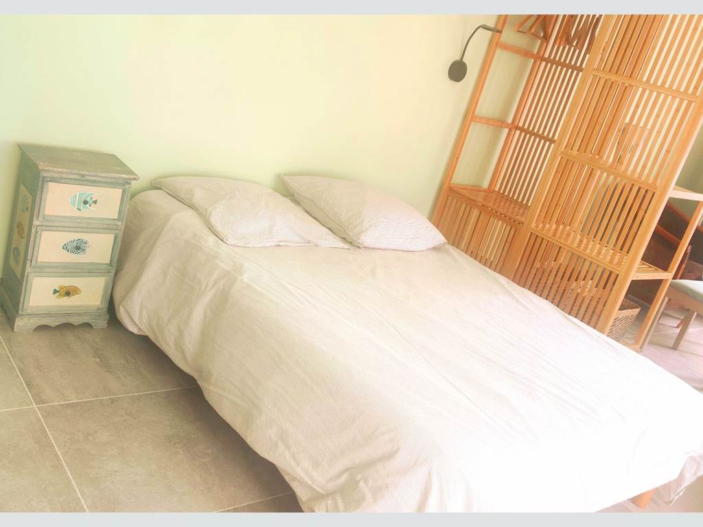 Chambre au style naturel et épuré Lit double, mobilier en bois clair et ambiance douce : parfait pour un séjour reposant au cœur de La Flotte