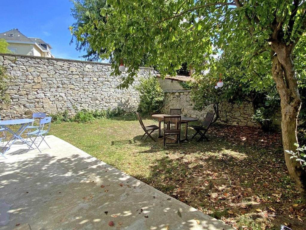 Terrasse du gîte avec tables extérieures et verdue