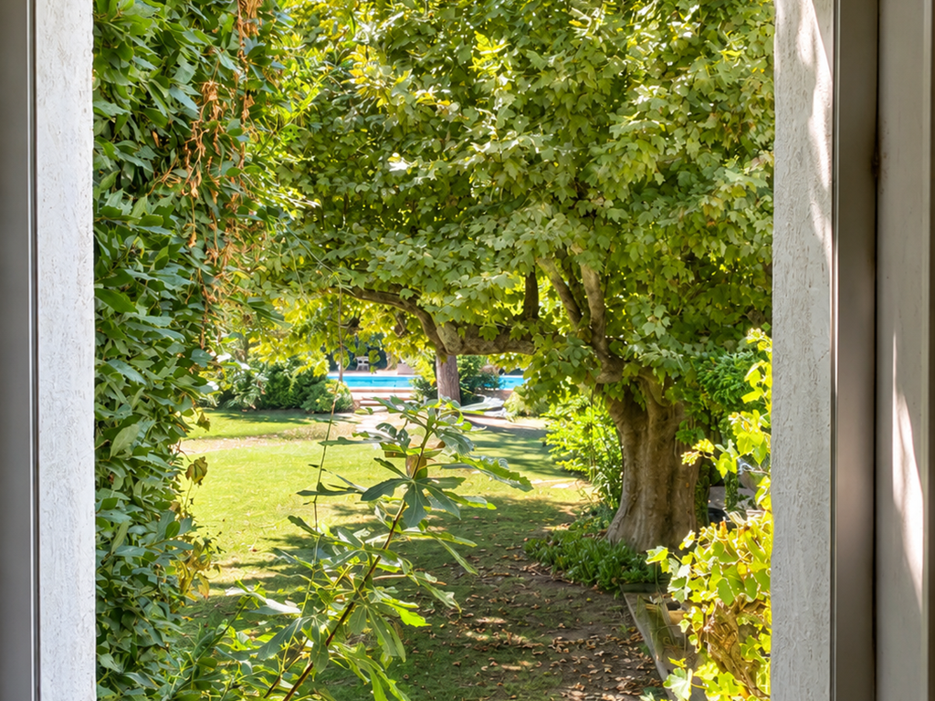 "Depuis la chambre, le regard s'ouvre sur le jardin arboré et la piscine du Mas"