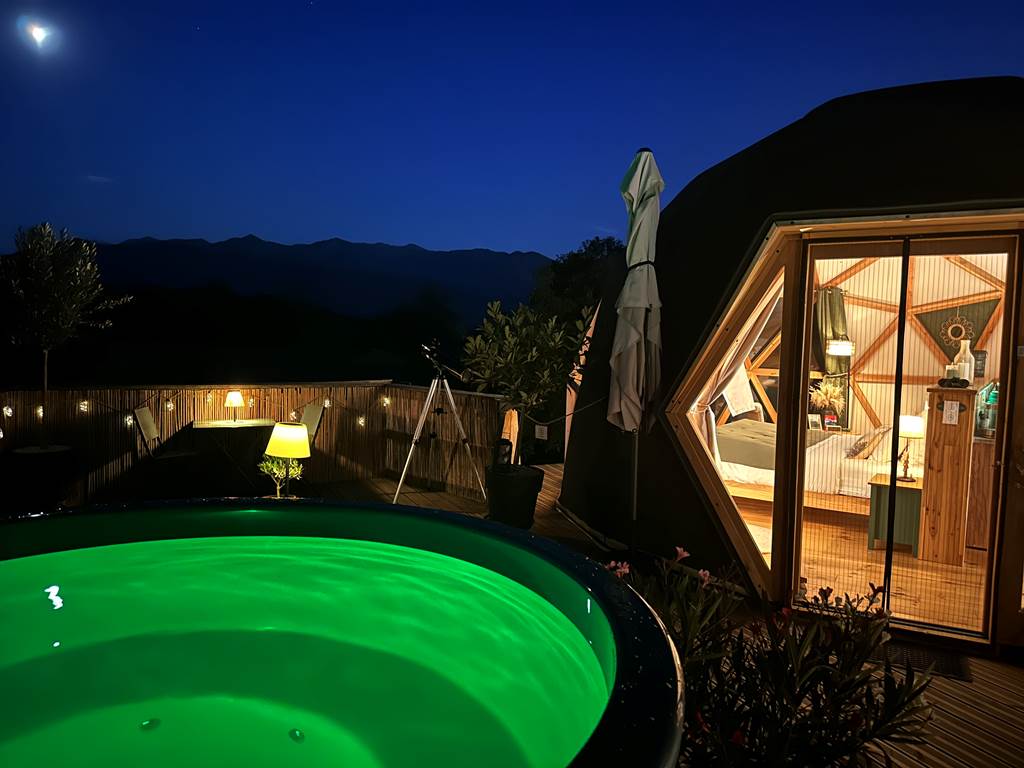 Profitez du bain nordique éclairé avec la vue sur les montagnes illuminées par la lune
