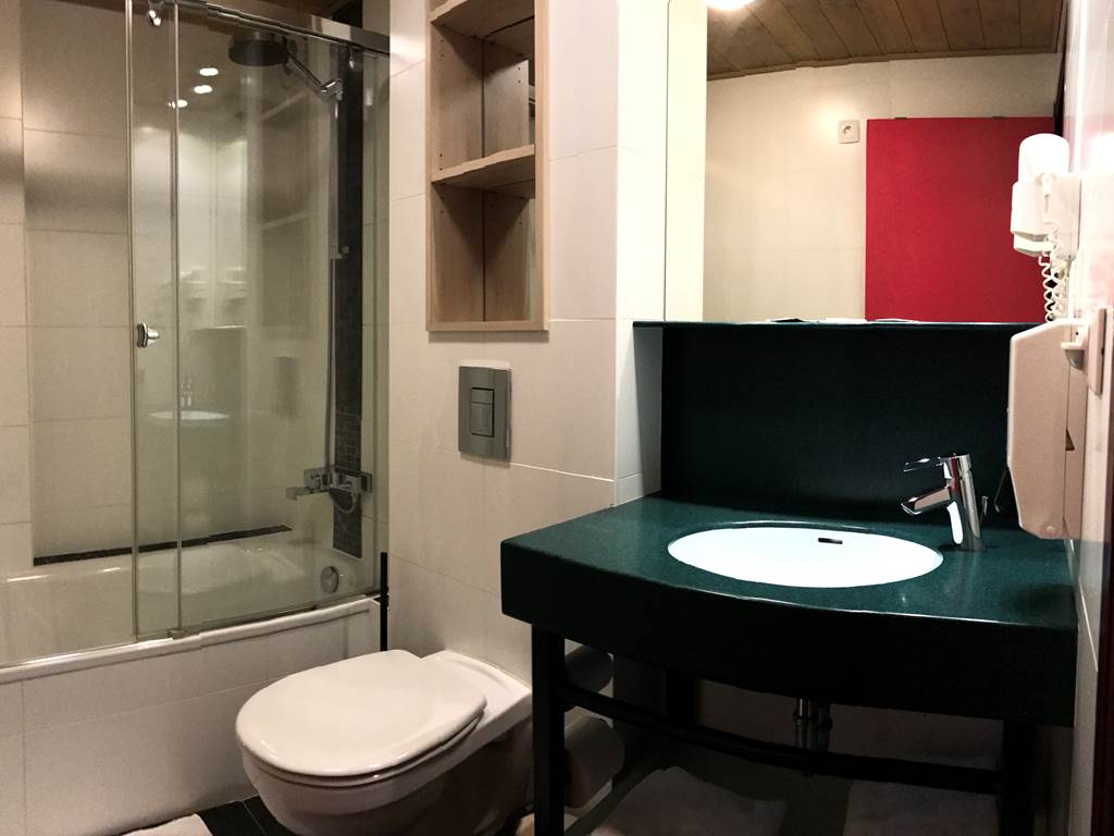 Salle de bain privative de la chambre Twin 13 comprenant une belle douche, un lavabo, un sèche cheveux et toilettes