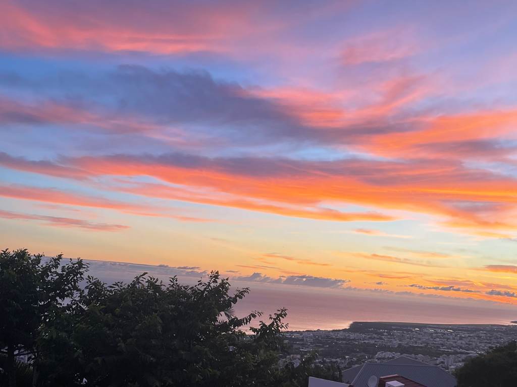 Lever de soleil aux couleurs spectaculaires sur l'océan Indien depuis la terrasse panoramique de la maison d'hôtes L’ESCAPADE BELLEPIERRE sur les hauteurs de Saint-Denis