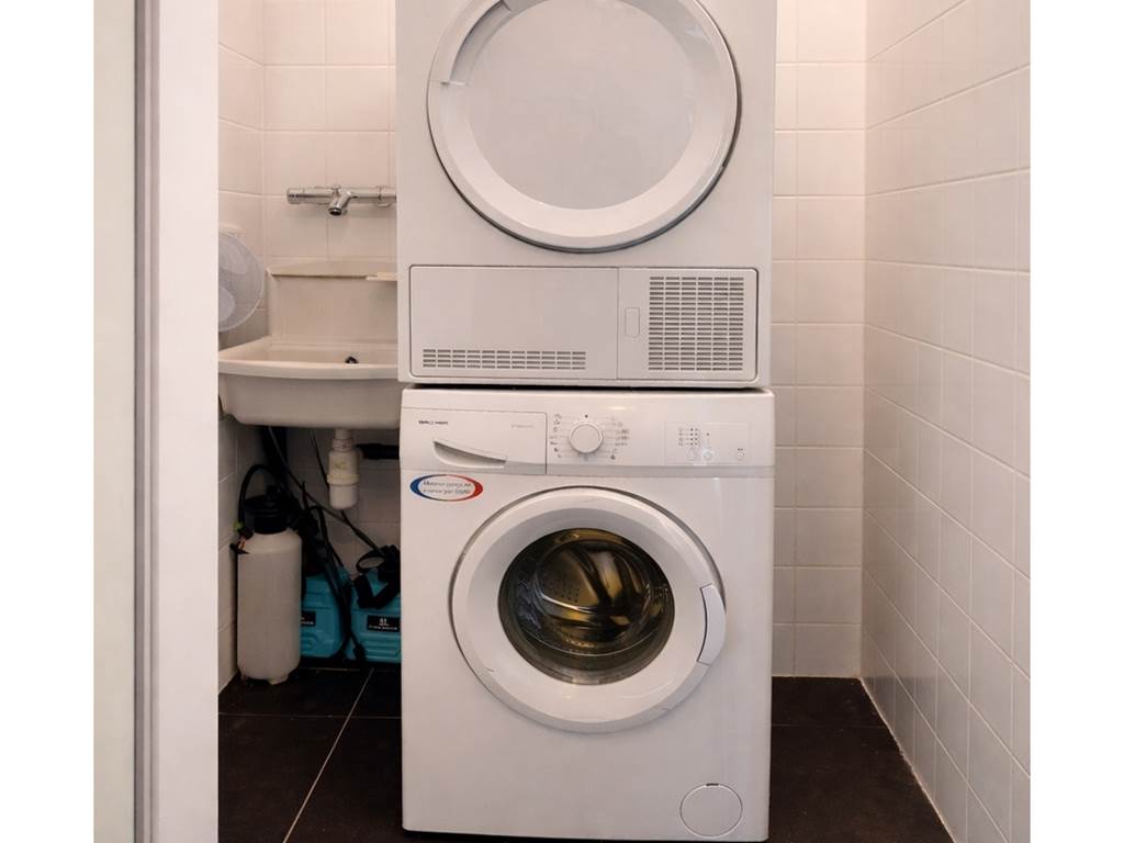 Espace buanderie équipé d’un lave-linge et d’un sèche-linge, pour un séjour confortable et sans contrainte.
