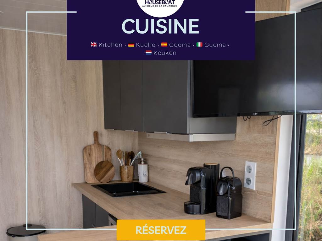 Cuisine entièrement équipée avec plaques de cuisson, four, micro-ondes, réfrigérateur, machine à café, bouilloire, ustensiles et vaisselle, offrant tout le nécessaire pour cuisiner en toute autonomie.