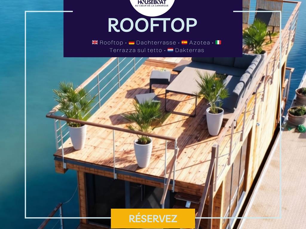 Grand rooftop avec salon extérieur et transats, offrant un espace de détente idéal avec vue dégagée sur l’eau et le paysage environnant.