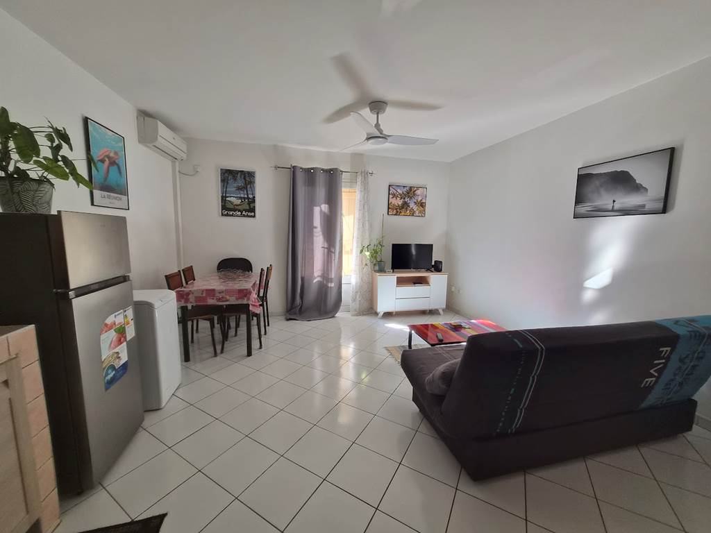 T2 Frangipanier climatiseur, séjour, vue d'ensemble, plaque de cuisson, table à manger