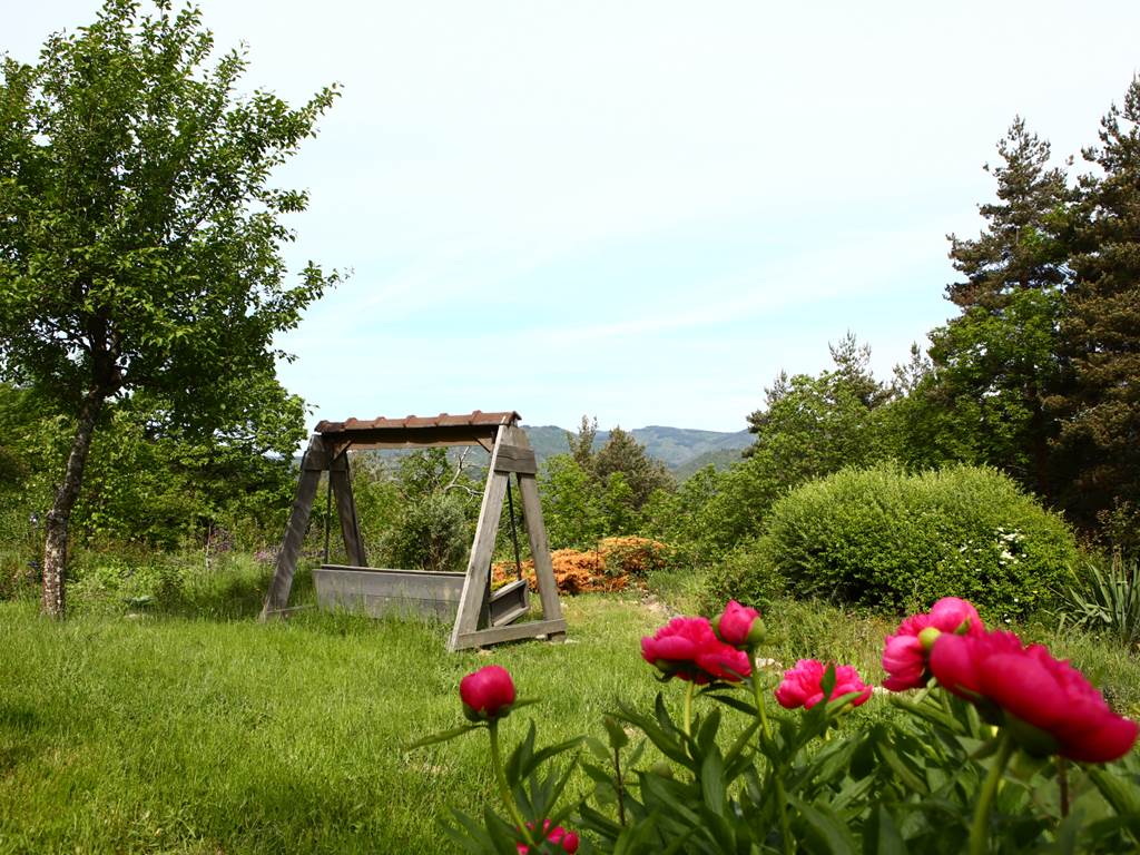 Vue extérieure jardin fleuri avec vue balancelle