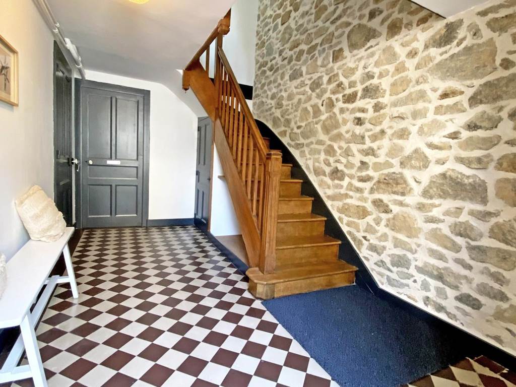 Entrée avec charme ancien, carrelage d’époque et escalier bois