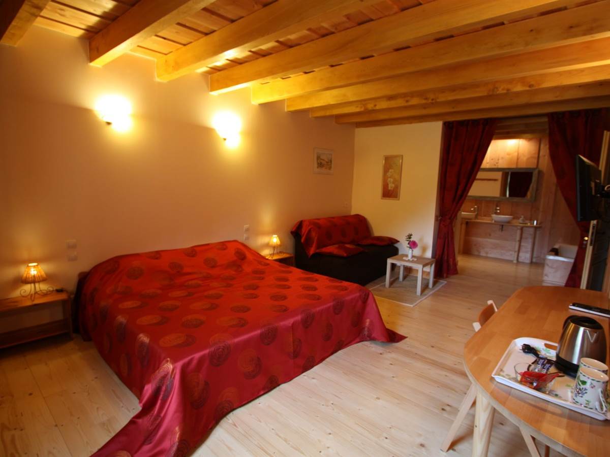 Vue d’ensemble de la chambre « Rubis » avec espace salon, TV, WIFI, Tisanerie