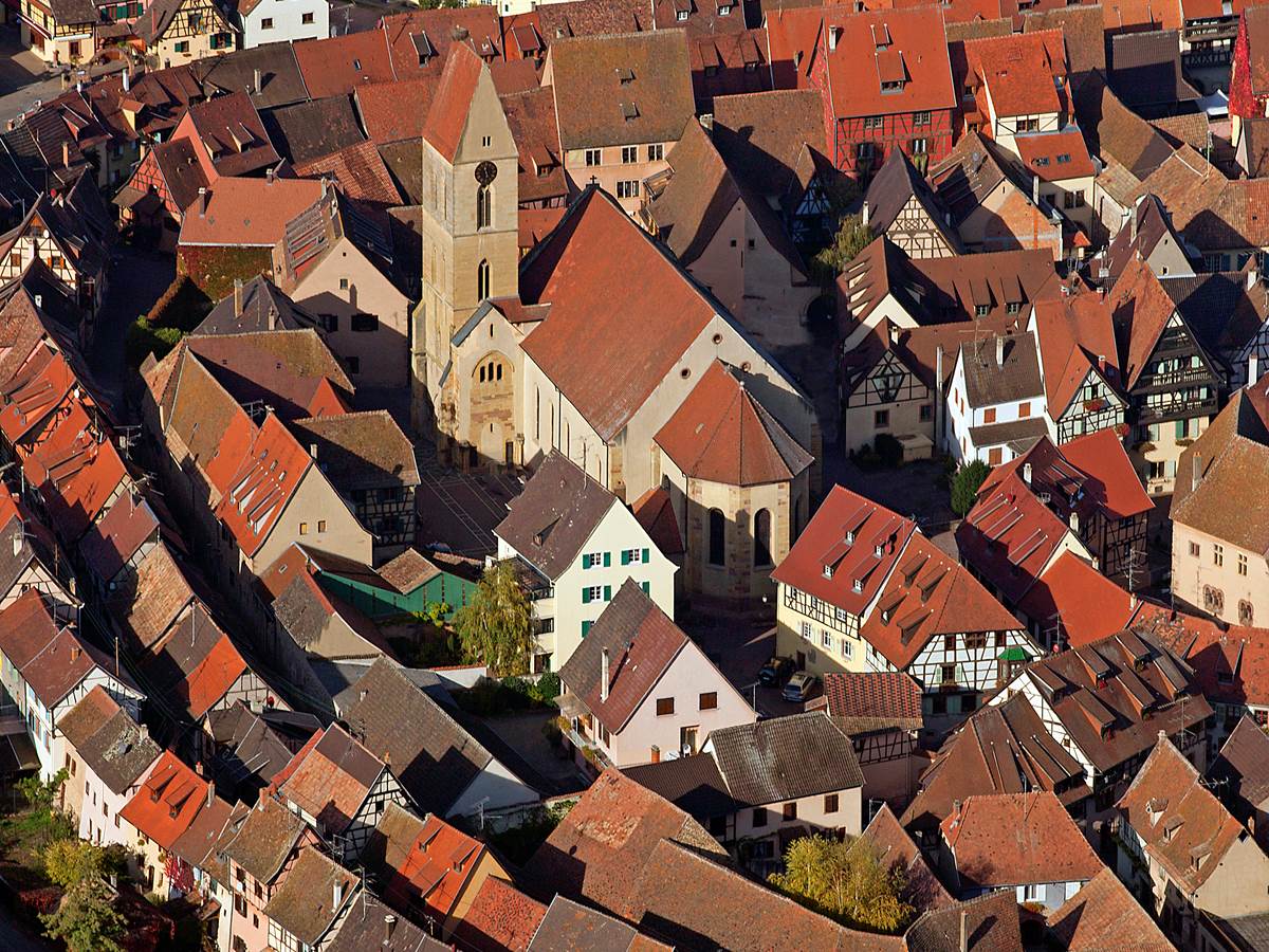 Vue aérienne de la cathédrale et du village d'Eguisheim aux ruelles concentriques