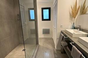 Salle de bain moderne avec grande douche à l’italienne et finitions soignées