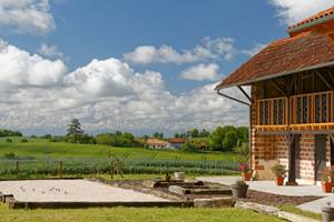 Vue plein Sud sur les Pyrénées. Terrain de pétanque, carrés potagers, environnement de verdure