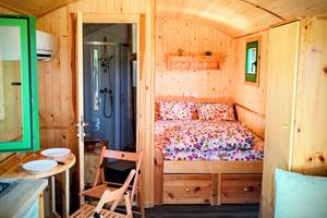 pièce principale roulotte - table dépliée pour 2 personnes