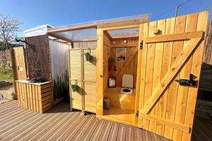 Espace sanitaire abrité à 2m du dôme, avec toilette sèche et douche