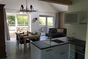 Vue cuisine sur salle à manger et terrasse