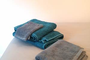 Ensemble de linge de maison composé de draps de lit, housse de couette, taie d'oreillers, serviette de bain et tapis de douche.