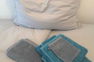 Linge de maison composé de draps de lit, housse de couette, taie d'oreillers, serviette de bain et tapis de douche.
