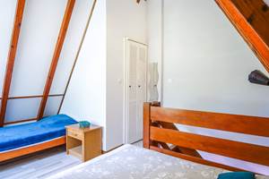 Le grand lit et le lit 1 personne dans la chambre mezzanine à l'étage