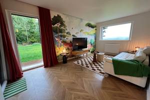 Salon avec le papier peint panoramique Forêt Isidore Leroy Créé à partir d'un dessin aquarellé de l'artiste Marion Bartherotte, le somptueux panneau Forêt édité par la maison Isidore Leroy présente un paysage côtier
