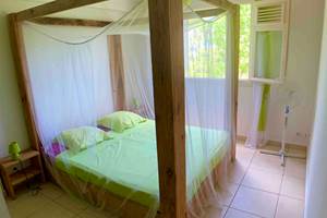 Chambre ventilée avec lit à baldaquin et moustiquaire