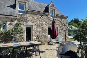 Facade maison avec table mise pour 6 et barbecue