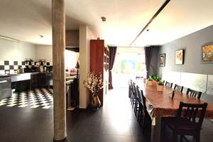 La grande table conviviale est juste à côté de la cuisine tout inox