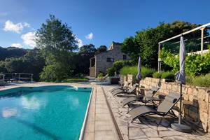 Espace détente avec transats modernes au bord de la piscine avec vue sur les montagnes.