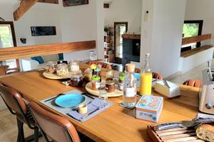 Salle à manger commune spacieuse et lumineuse pour un accueil familial et convivial.