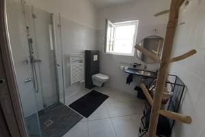 Salle de douches accessible aux personnes à mobilité réduite (grande douche, WC et vasques)