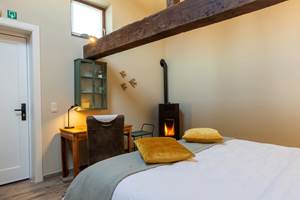 poelle à pellets, bureau et table petit déjeuner, 2 fauteuils confortables, thé, café à disposition