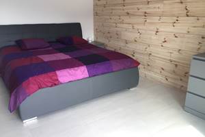 Chambre avec lit King size et mur en bois finlandais