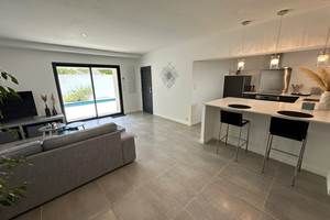 Salon contemporain baigné de lumière, idéal pour se détendre après une journée au soleil