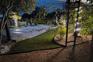 Ambiance estivale en soirée autour de la piscine chauffée de notre maison d'hôtes