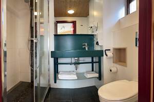 Salle de bain privative des Chambres 11 - 21 comprenant une belle douche Italienne, un lavabo, un sèche cheveux et toilettes